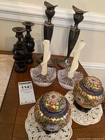Photo showing the full lot including silver-tone bird candle holders, two dark candlesticks, clear glass candle holders with candles, and the cloisonné ginger jars on doilies.