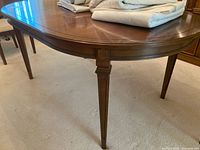 Photo showing the full length side view of the wood dining table and tapered leg design.