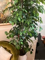 Faux potted tree showing full height and foliage against living room background.