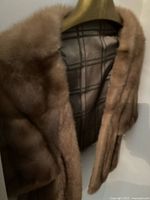 Brown mink stole hanging showing exterior fur and checked textile lining interior