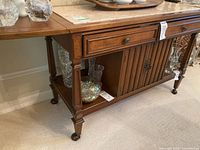 Front view of cart showing stone top, center drawer, louvered doors and lower shelf