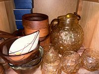 Image showing vintage amber textured glass pitcher with lid, 4 matching textured glasses, wood salad bowls stacked, and two clear glass bowls.