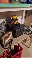 Photo showing Black & Decker jigsaw, sander, and Mor-Power drill on shelf.