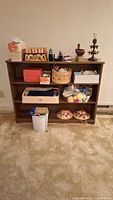 Full view of wooden shelving unit with many boxes and containers holding sewing and knitting supplies including hats, yarn, and notions.