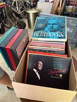 Box showing a box with various vinyl record sets including Nat King Cole, Beethoven, and others visible on top