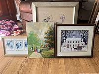 Full view of four framed art prints on floor showing all four artworks and frames