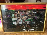 Full view of the framed Las Vegas Strip aerial night poster showing bright lights and cityscape under a red sky.