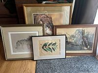 Group photo showing all four framed pieces including the Robert Bateman wolf print and other animal and botanical prints arranged on floor.