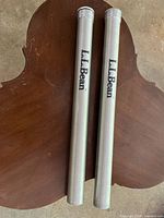 Two aluminum tubes with L.L. Bean logo, used for storing fishing rods