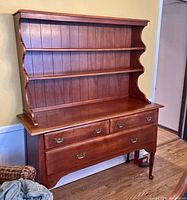 Front view of the maple colonial Cushman breakfront hutch showing upper open shelving and drawer configuration.