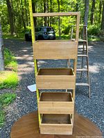 Front view of the wooden organizer showing all four angled bins and height tape measure for scale.
