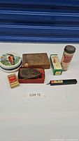 All items displayed on a white background including round ceramic container, wooden box, matchbox, and other vintage tools.