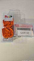 Photo showing one pack of orange PaWZ rubber dog boots and one set of Ninety-nine Dreams false eyelashes with lot label.