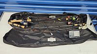 Overview photo of all six fishing rods with reels laid out inside a black soft carry case with visible cork handles and rods of different colors.