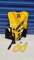 Full view of bright yellow Fluid life jacket with adjustable straps and 2 yellow floating wrist straps in front