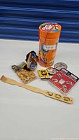 Photo showing Jenga-style game container, wooden golf tees, goggles, SpongeBob belt, cartoon face belt, decorative belt, Toyota wheel locks, wooden back scratcher