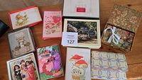 Top-down view showing boxed greeting cards and two decorative fabric-covered boxes with ribbons and autumn motifs.