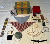 Full view of lot including all doll accessories, dolls, teddy bears, miniature books, shawls, bonnets, aprons and vintage Baby's Trunk box