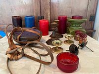 Four pillar candles along with three sets of two taper candle holders, a pillar candle holder and a unique candle in a leather hanging holder