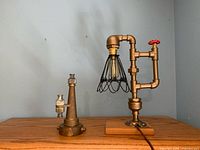 Full view of both the industrial style lamp and the antique firehose nozzle showing size relation and condition