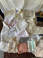 Entire lot spread out on surface showing multiple lace and embroidered pieces of varying sizes and textures