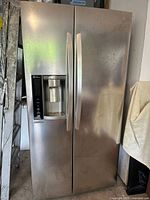 Full front view of the stainless steel LG side-by-side refrigerator with freezer and dispenser showing doors and handles.