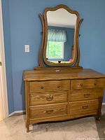 Front view of the oak dresser showing all six drawers and the mirror attached on top.