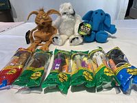 Eight PEZ dispensers are lined up in original green packaging, front view showing character heads and packaging details.