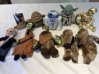 Full set of six Star Wars Buddies plush toys laid out on white backdrop including R2-D2, Yoda, Jabba the Hutt, C-3PO, Chewbacca (two plush), with original tags visible as well as Star Wars trading card pack.