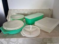 Photo showing all five Tupperware pieces arranged on a table: long crisper, relish dish, jello mold, flat box and grater with lids.