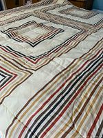 Twin size comforter laid flat displaying concentric square striped pattern in 1980s style colors.