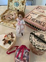 Image showing doll standing beside various small decorative boxes and miniature dressing table accessories.