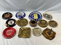 Group shot displaying 11 of the advertising ashtrays front-side