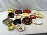 Group shot of all fifteen advertising ashtrays