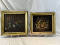 Both framed still life oil paintings side by side