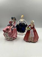 Front view of three Royal Doulton figurines