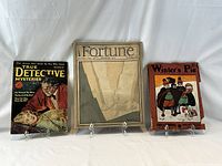 Front covers of all three magazines displayed on stands