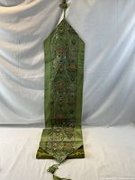 Full length view of green silk brocade runner hanging to show size and pattern