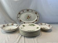 Front view showing stacked Trillium plates, Petit Point platter and two bowls