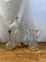 Four crystal pieces grouped: three decanters and one pitcher