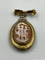Front view showing shell cameo of three women in gold-filled frame