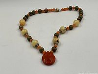 Full view of necklace showing bead pattern, clasp and pendant