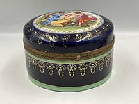 Closed trinket box showing lid artwork and gold gilt pattern