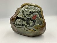 Front view showing carved tree, figures, animals, red accent