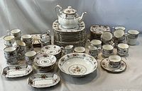 Full set stacked and arranged showing range of plates, cups, teapot, bowls, serving pieces