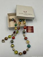 Necklace displayed, bracelet in box, authenticity card and box lid visible