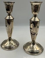 Front view of both sterling silver candlestick holders