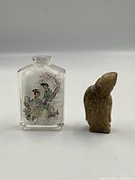 Snuff bottle and stone figure together for scale and comparison