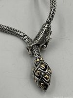 Close-up of dragon head and tail clasp showing sterling detail and 18K accents