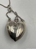 Front view of sterling heart perfume bottle pendant on short decorative chain segment